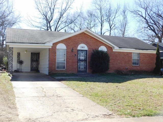 ranch-style house with driveway, brick siding, a front yard, and a shingled roof