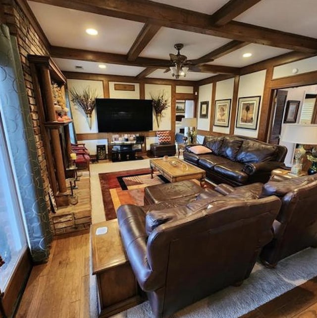 living area featuring a ceiling fan, coffered ceiling, hardwood / wood-style floors, and beamed ceiling