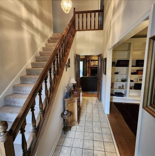 foyer featuring baseboards, a high ceiling, and light tile patterned floors