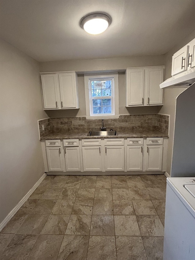 kitchen featuring under cabinet range hood, a sink, white cabinets, and decorative backsplash