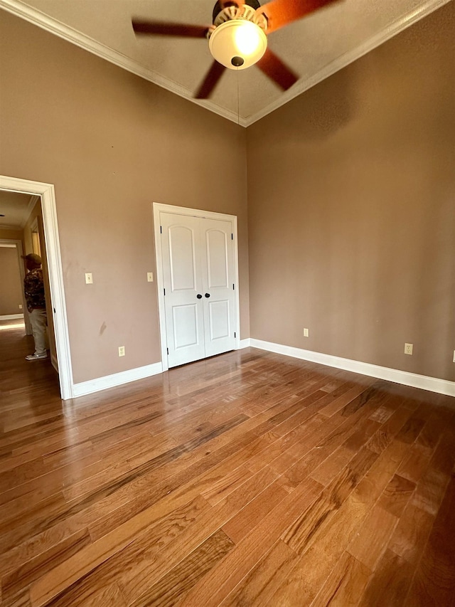 unfurnished bedroom with ornamental molding, wood finished floors, and baseboards