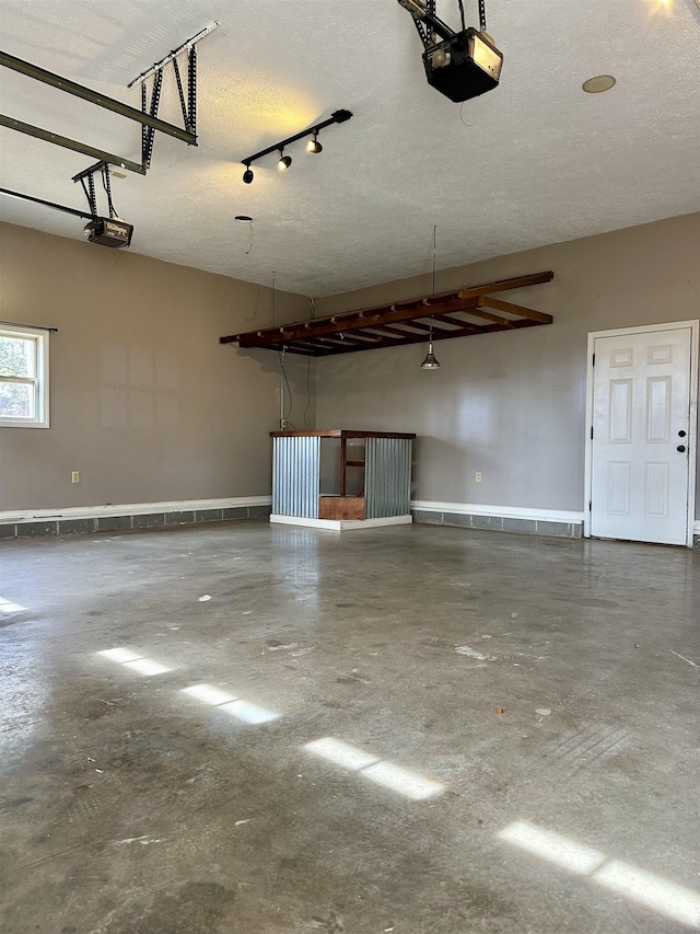 garage with baseboards and a garage door opener