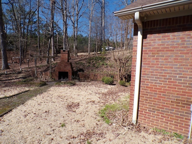 view of yard with an outdoor fireplace