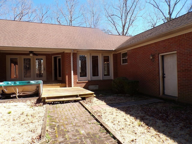 back of property featuring a shingled roof, brick siding, and a wooden deck