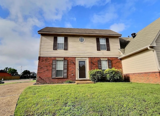 view of front of home featuring brick siding and a front yard