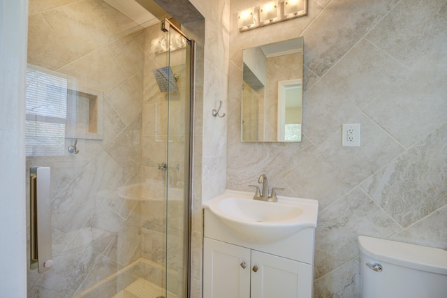 full bathroom with toilet, a stall shower, vanity, and tile walls