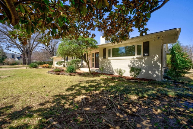 view of front facade featuring brick siding, a garage, and a front yard