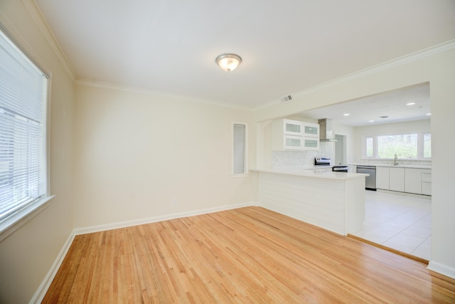 unfurnished living room featuring crown molding, baseboards, light wood-type flooring, and visible vents