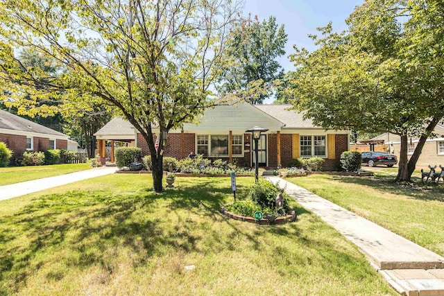 view of front of home with a front yard, concrete driveway, and brick siding