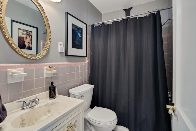 bathroom featuring wainscoting, toilet, curtained shower, vanity, and tile walls