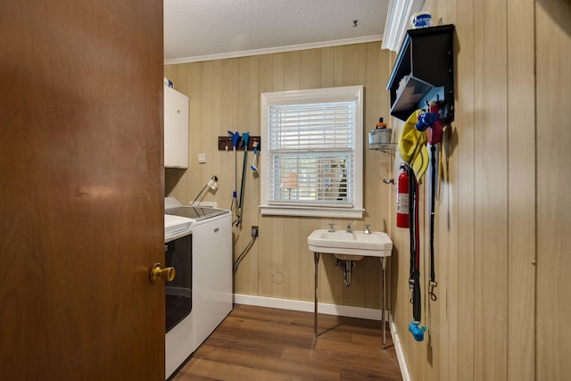 laundry area with crown molding, cabinet space, a textured ceiling, wood finished floors, and independent washer and dryer