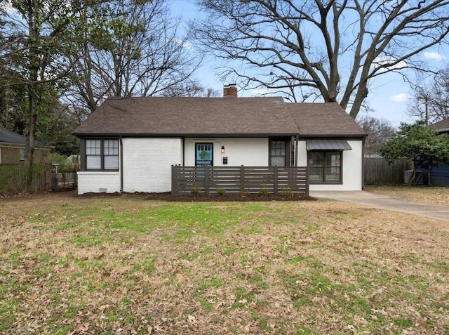 ranch-style home featuring a shingled roof, a chimney, fence, a front lawn, and brick siding