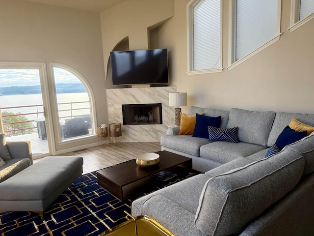 living room featuring tile patterned flooring, a premium fireplace, and baseboards