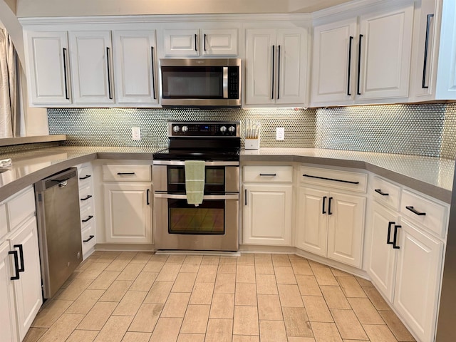 kitchen with tasteful backsplash, white cabinetry, and stainless steel appliances