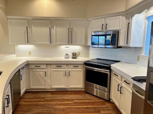 kitchen featuring light countertops, appliances with stainless steel finishes, dark wood-style flooring, and white cabinets