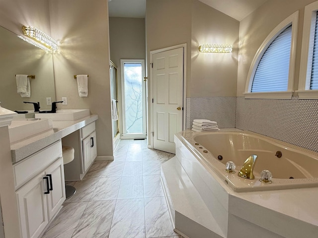 bathroom featuring a sink, marble finish floor, a shower stall, a whirlpool tub, and double vanity