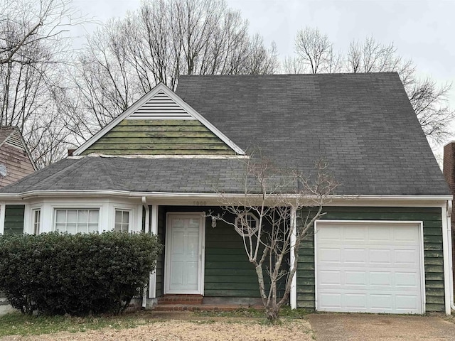 view of front of home with a garage, driveway, and roof with shingles