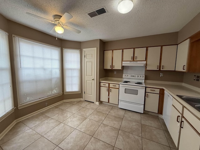 kitchen with light countertops, white appliances, visible vents, and under cabinet range hood