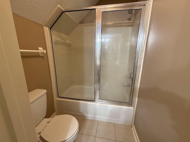 bathroom featuring a textured ceiling, shower / bath combination with glass door, tile patterned flooring, and toilet