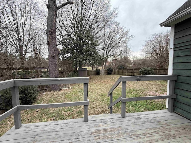 wooden terrace with a fenced backyard