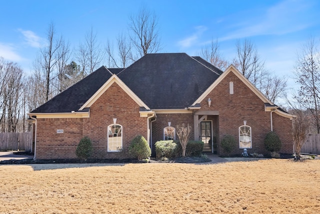 view of front of property featuring fence and brick siding