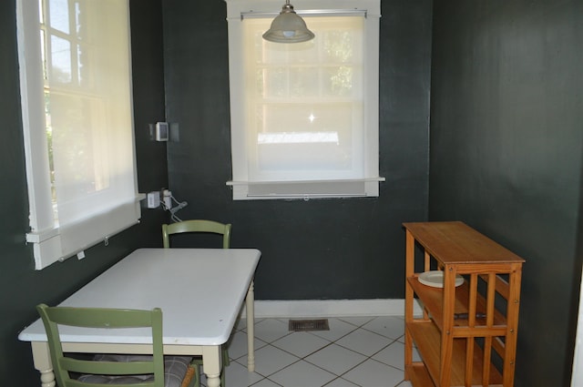 dining space featuring light tile patterned floors, visible vents, and baseboards