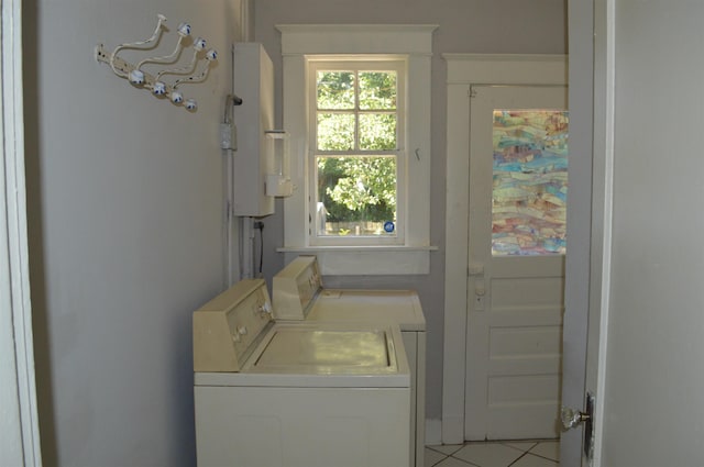 clothes washing area with laundry area, water heater, independent washer and dryer, and tile patterned floors