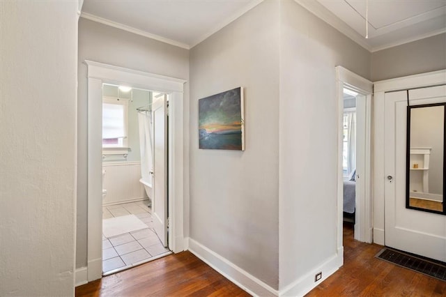 hallway with crown molding, baseboards, and wood finished floors