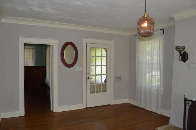 doorway with dark wood-type flooring, crown molding, and baseboards