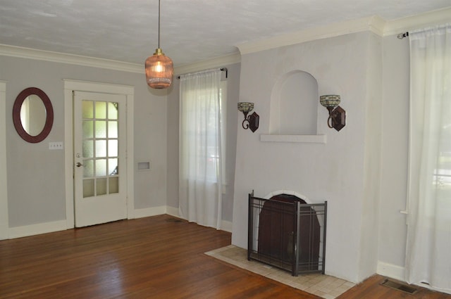 entryway featuring a fireplace with flush hearth, ornamental molding, wood finished floors, and visible vents