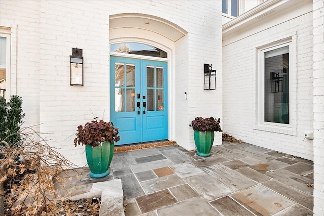 view of exterior entry with french doors and brick siding