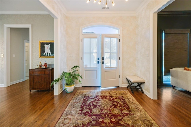 entrance foyer featuring crown molding, wood finished floors, and an inviting chandelier