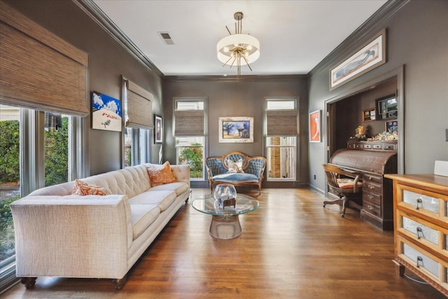 living room with baseboards, visible vents, crown molding, and wood finished floors