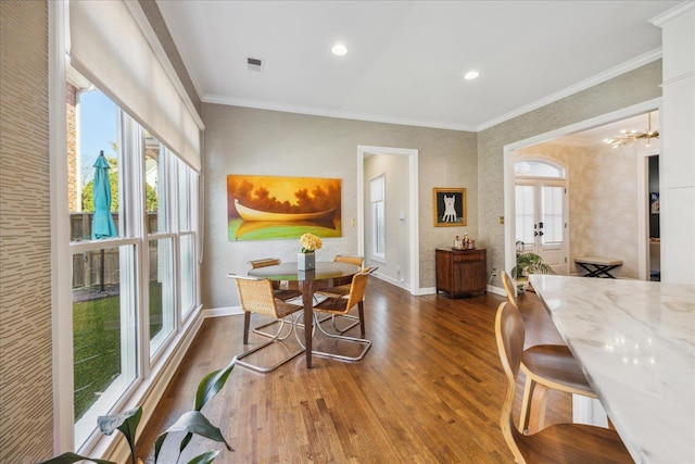 dining space featuring visible vents, baseboards, dark wood-style flooring, an inviting chandelier, and crown molding