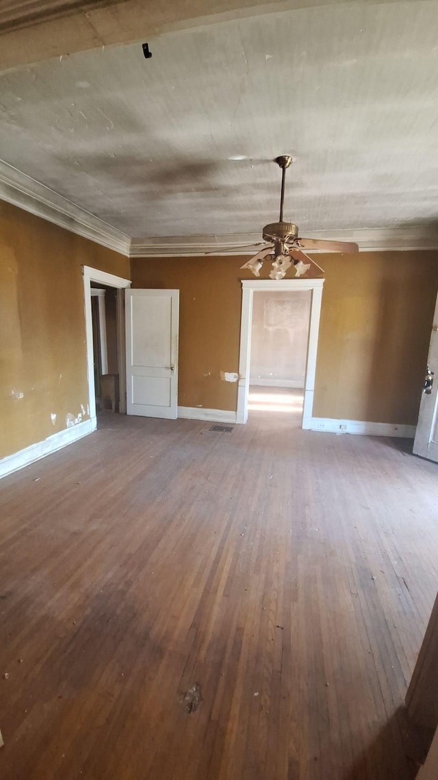 interior space with ornamental molding, visible vents, baseboards, and hardwood / wood-style flooring