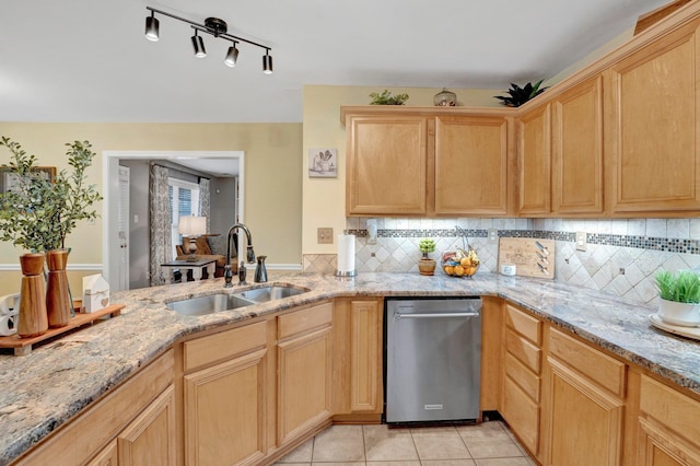 kitchen with light brown cabinets, a sink, backsplash, light tile patterned floors, and light stone countertops