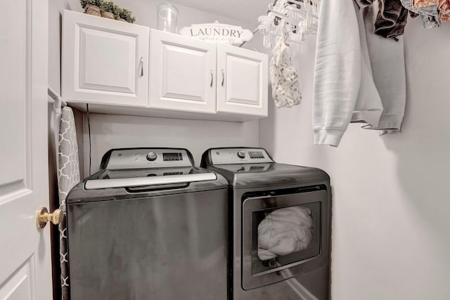 clothes washing area featuring cabinet space and washer and dryer