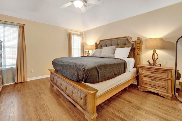 bedroom featuring a ceiling fan, lofted ceiling, light wood-style floors, and baseboards