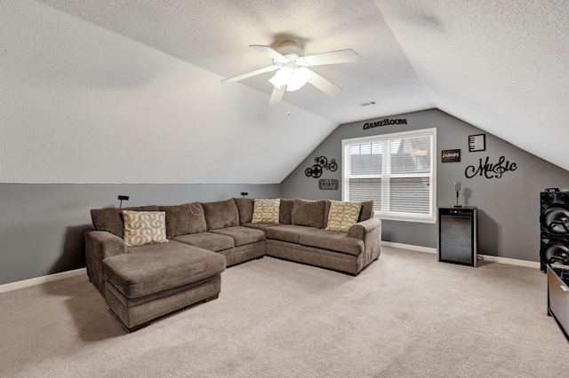 living area featuring visible vents, lofted ceiling, a textured ceiling, baseboards, and light colored carpet