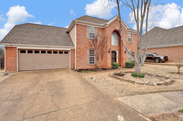 colonial inspired home with brick siding, concrete driveway, a garage, and roof with shingles