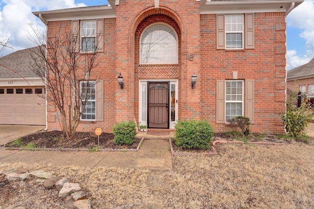 view of front of home with an attached garage and brick siding