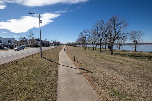 view of street featuring street lighting, a water view, and sidewalks