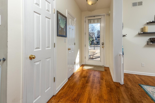 entryway featuring visible vents, baseboards, and wood finished floors