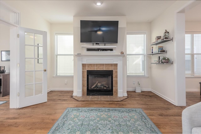 living room with plenty of natural light, a fireplace, and wood finished floors