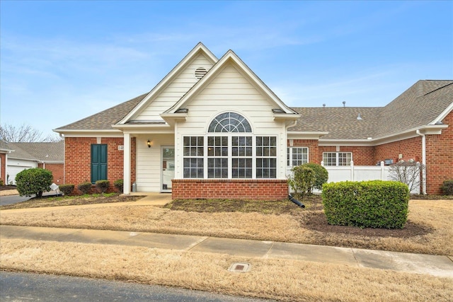 view of front of property with brick siding and a shingled roof