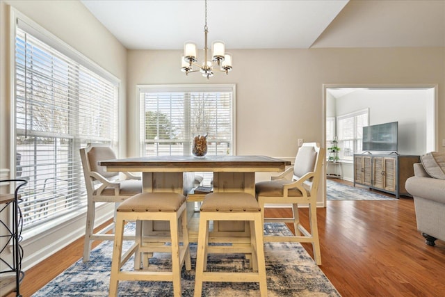 dining room with baseboards, an inviting chandelier, and wood finished floors