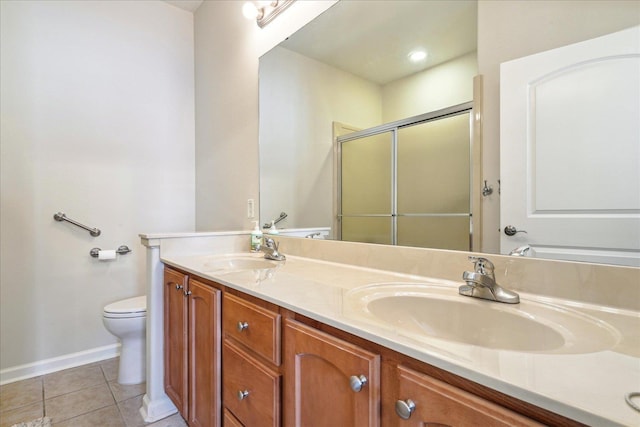 bathroom with double vanity, a sink, a shower stall, and tile patterned floors