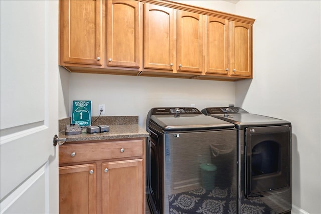 washroom featuring cabinet space and independent washer and dryer