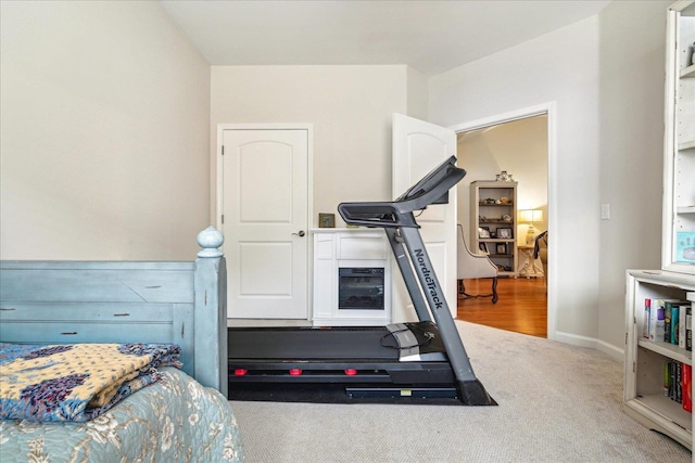 exercise room featuring baseboards and carpet flooring