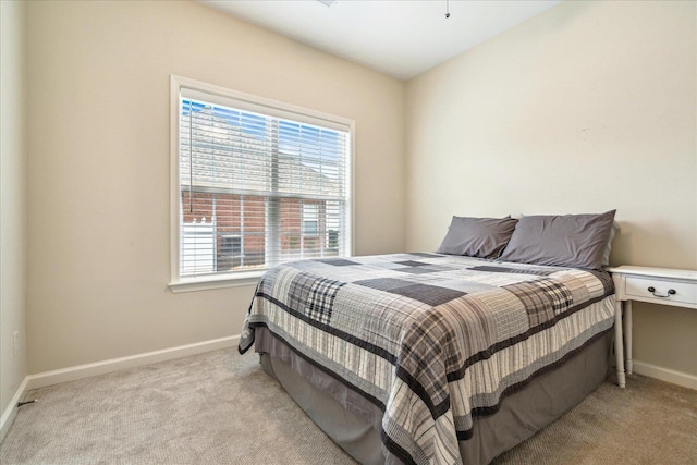 bedroom with light colored carpet and baseboards